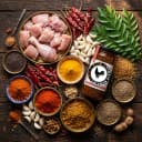 Fresh ingredients for Andhra Store Chicken Pickle — red chillies, garlic, curry leaves and whole spices