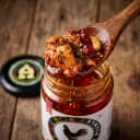 Chicken Pickle — close-up of spiced oil and pickle pieces on wooden spoon