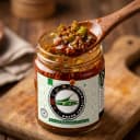Green Chilli Pickle — close-up of spiced oil and pickle pieces on wooden spoon