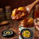 Lemon Pickle — close-up of spiced oil and pickle pieces on wooden spoon