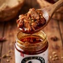 Mutton Pickle — close-up of spiced oil and pickle pieces on wooden spoon