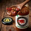 Red Chilli Pickle — close-up of spiced oil and pickle pieces on wooden spoon