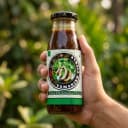 Hand holding Andhra Store Tamarind Pickle jar outdoors — authentic homemade pickle