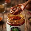 Tamarind Pickle — close-up of spiced oil and pickle pieces on wooden spoon